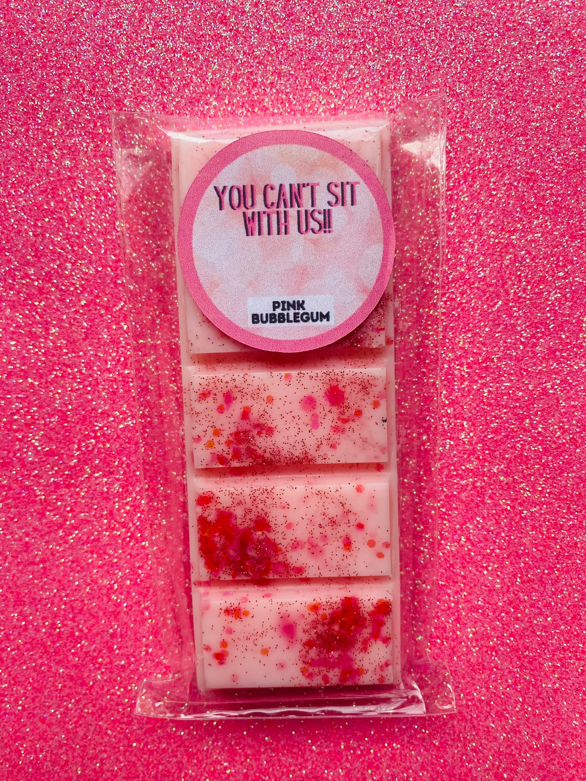 wax melts inspired by the Mean Girls movie, each with different colors and labels corresponding to different quotes from the film.